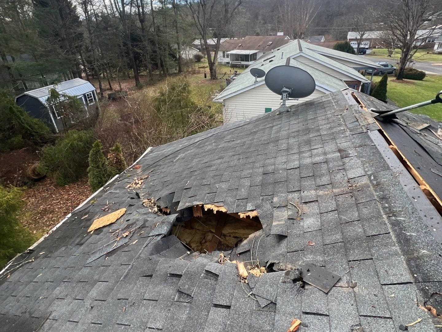 Damaged roof with missing shingles and structural breach analyzed by Phototology for insurance claim